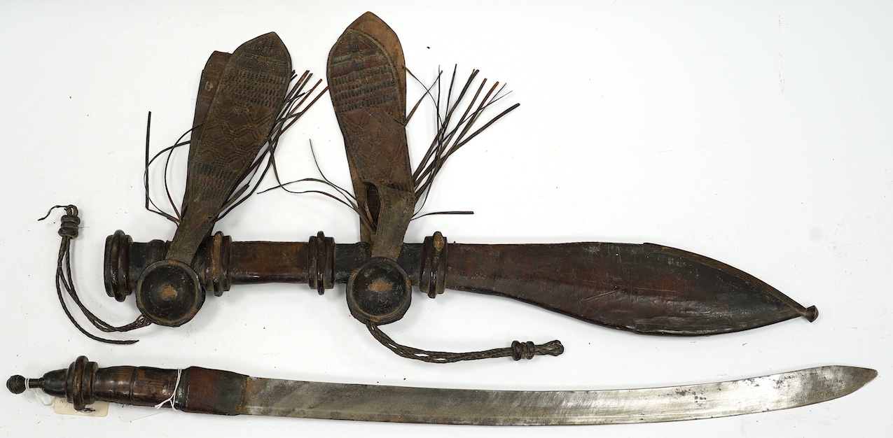 A late 19th century Nigerian Taboura from the Hausa People of Northern Nigeria, in leather scabbard, blade 55.5cm. Condition - good